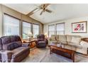 Comfortable living room with a ceiling fan, large windows, and plush seating at 17200 W Bell Rd # 2162, Surprise, AZ 85374