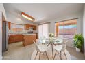 Cozy kitchen and dining area with stainless steel appliances, wood cabinets, and a sunlit breakfast table at 17910 N 92Nd Ln, Peoria, AZ 85382