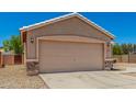 The exterior features a two-car garage with stone accents, a desert landscaped yard and a tile roof at 2018 N 104Th Dr, Avondale, AZ 85392