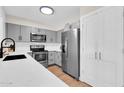 Modern kitchen featuring stainless steel appliances, gray cabinets, and quartz countertops at 2324 E Crescent Ave, Mesa, AZ 85204