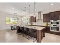 Modern kitchen featuring stainless steel appliances, a large island with seating, and contemporary lighting at 24840 S 195Th St, Queen Creek, AZ 85142