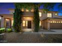 Charming two-story home at dusk with a well-manicured front yard and stone accents on the entrance at 2541 E Carob Dr, Gilbert, AZ 85298