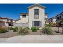 View of a two-story home with neutral stucco, grey shutters, desert landscaping, and a balcony at 26505 N Babbling Brook Dr, Phoenix, AZ 85083