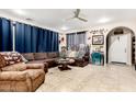 Comfortable living room with tile flooring, a ceiling fan, a plush sectional sofa, and an arched doorway at 2944 N Brighton --, Mesa, AZ 85207