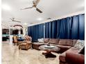 Spacious living room featuring tile floors, ceiling fans, and comfortable seating, adjacent to the dining area and kitchen at 2944 N Brighton --, Mesa, AZ 85207