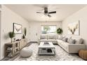 Bright living room featuring a ceiling fan, stylish decor, a light-colored sofa, and a large window at 3114 W Villa Maria Dr, Phoenix, AZ 85053
