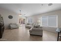 Bright living room with tiled floor, ceiling fan, and sliding glass doors to the backyard patio at 3905 E Derringer Way, Gilbert, AZ 85297