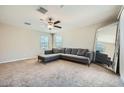Spacious living room with a comfortable sectional sofa, ceiling fan, and a full length mirror at 3916 S 79Th Ln, Phoenix, AZ 85043
