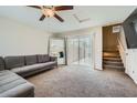 Cozy living room featuring plush carpeting, a ceiling fan, a large mirror, and a sliding glass door at 3916 S 79Th Ln, Phoenix, AZ 85043
