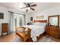 Inviting main bedroom with hardwood floors, a ceiling fan, and a cozy seating area, flooded with natural light at 4013 E Delta Cir, Mesa, AZ 85206