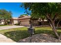 Well-maintained home with mature trees and landscaping, featuring a neatly kept lawn and driveway at 4037 E Elmwood St, Mesa, AZ 85205