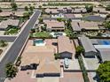 Aerial view showcasing a home with a private pool and detached garage in a well-maintained neighborhood at 4701 W Fallen Leaf Ln, Glendale, AZ 85310