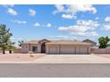 Charming single-story home boasting a three-car garage and low-maintenance desert landscaping on a sunny day at 4701 W Fallen Leaf Ln, Glendale, AZ 85310