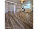 Open floor plan showcasing new wood floors connecting the living room to the kitchen and dining areas at 4911 W Merrell St, Phoenix, AZ 85031