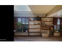 A cozy living room featuring custom shelving, wooden shutters, a skylight, and decorative plants that add natural charm at 498 W Gail Dr, Chandler, AZ 85225