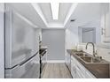 Well-lit kitchen featuring stainless steel appliances, white cabinets, and wood-look flooring at 616 S Hardy Dr # 203, Tempe, AZ 85281