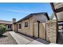 Side view of a single-story home with light brick and a private gated patio at 6415 S Newberry Rd # A, Tempe, AZ 85283