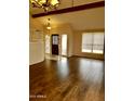 Bright living room with wood floors, a vaulted ceiling and an entry way with decorative windows at 7537 W Dreyfus Dr, Peoria, AZ 85381