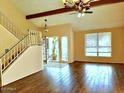 Bright living room with wood floors, a vaulted ceiling and a staircase at 7537 W Dreyfus Dr, Peoria, AZ 85381