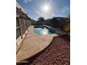 Backyard pool featuring unique stonework, small rocks, a handrail, and privacy fence at 8254 E Posada Ave, Mesa, AZ 85212