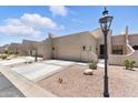 This townhome features a two-car garage, desert landscaping, and entry with an iron gate at 8785 E Greenview Dr, Gold Canyon, AZ 85118
