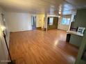 Open-concept living room featuring hardwood floors and views into the kitchen area with natural light at 9501 E Broadway Rd # 68, Mesa, AZ 85208