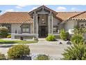 Inviting home entrance with stone columns, lush landscaping, and a welcoming front yard at 1015 E Paradise Ln, Phoenix, AZ 85022
