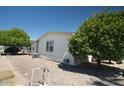 Well-maintained single-story home with desert landscaping, mature trees, and a convenient outdoor area at 11596 W Sierra Dawn Blvd # 182, Surprise, AZ 85378