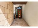 Stylish entryway with a modern orange door, stone wall, and neutral color palette at 1217 E Monte Way, Phoenix, AZ 85042