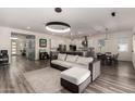 Open-concept living room with a modern sofa, light fixtures and a spacious kitchen at 1217 E Monte Way, Phoenix, AZ 85042