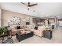 Cozy living room showcasing an oversized sectional sofa, ceiling fan, and seamlessly connects to the kitchen at 1284 W Sussex St, San Tan Valley, AZ 85143