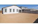 A well-kept lot showing a clean, neutral stucco exterior, and a pristine dirt backyard with block fencing at 17734 W Turquoise Ave, Waddell, AZ 85355
