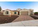 Charming single-story home with a three-car garage, desert landscaping, and a brick driveway at 18371 W Roma Ave, Goodyear, AZ 85395