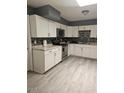 Modern kitchen boasts sleek white cabinets, stainless steel appliances, and eye catching black and white mosaic tile backsplash at 2019 E Southern Ave, Phoenix, AZ 85040
