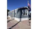 Well-maintained mobile home with blue siding, white trim, and mature landscaping at 2600 E Allred Ave # R-88, Mesa, AZ 85204