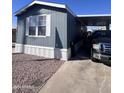 Cozy mobile home featuring blue siding, white trim, and convenient covered parking at 2600 E Allred Ave # R-88, Mesa, AZ 85204