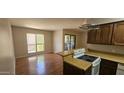 Efficient kitchen with appliances, breakfast bar, and sliding doors to the patio at 3131 W Cochise Dr # 256, Phoenix, AZ 85051