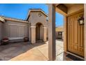 Inviting entryway with tiled porch leading to a tan-colored door at 42625 W Sandpiper Dr, Maricopa, AZ 85138