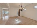 Spacious living room with natural light and a decorative chandelier at 42625 W Sandpiper Dr, Maricopa, AZ 85138