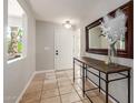 Inviting foyer with tile flooring, natural lighting, a console table with decor, and a large mirror at 6417 E Kings Ave, Scottsdale, AZ 85254
