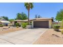 Single-story home featuring desert landscaping, a brick facade, and a two-car garage with a concrete driveway at 6417 E Kings Ave, Scottsdale, AZ 85254