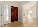 Well lit foyer with tile flooring, decorative glass block window, and entry to the dining room at 7108 W Morrow Dr, Glendale, AZ 85308