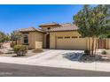 Beautiful tan home featuring a tile roof, desert landscaping, and an attached two-car garage at 7665 W Fetlock Trl, Peoria, AZ 85383