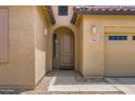 Close-up view of the home's entrance, showcasing an arched doorway and desert landscaping at 7665 W Fetlock Trl, Peoria, AZ 85383