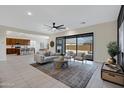 Bright living room with a ceiling fan, sliding glass doors, and views into the kitchen at 8027 W Northview Ave, Glendale, AZ 85303