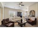 Cozy living room featuring plantation shutters, a ceiling fan, and neutral decor at 8820 E Ivy Cir, Mesa, AZ 85207