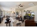 Open-concept living room with a ceiling fan and easy access to the kitchen and dining area at 8820 E Ivy Cir, Mesa, AZ 85207
