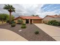 Charming home with mature landscaping, decorative stone, and a spacious driveway at 9085 E Windrose Dr, Scottsdale, AZ 85260