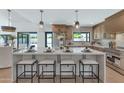 Bright kitchen island with seating, stainless steel appliances, and view of the backyard at 9450 N 83Rd Pl, Scottsdale, AZ 85258
