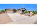 Expansive driveway leads to a well-maintained single-story home with a two-car and single-car garage at 10664 E Ellis St, Mesa, AZ 85207